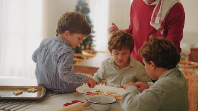 Boys decorating Christmas cookies