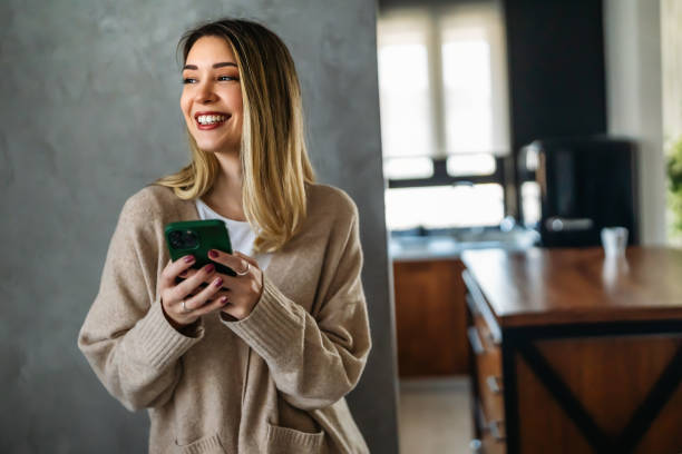 istock Smiling young woman chatting in social networks, working, using mobile applications at home. 1794953383