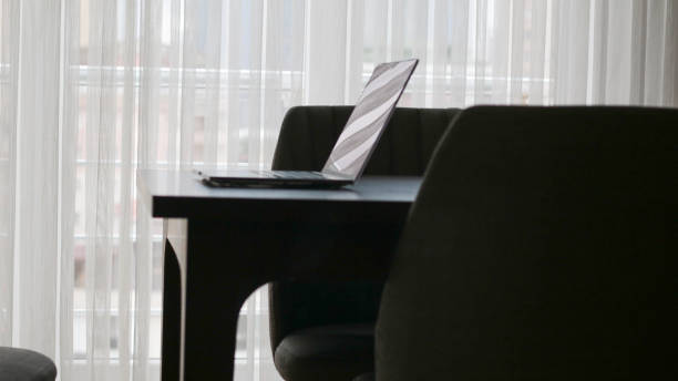 istock Laptop and laptop on table near window curtains 1794957196