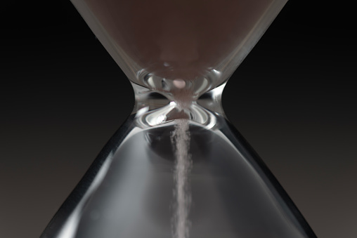Sandglass, black background, close-up.