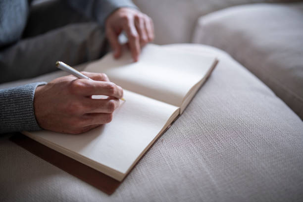 istock Close-up of unrecognizable man writing on notepad. 1794971660