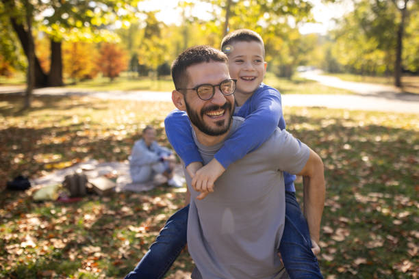 istock Father carrying his son on his back while on a picnic 1794983317