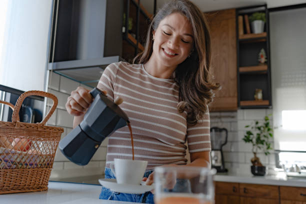 istock Beautiful young woman preparing coffee with a home espresso coffee maker 1794985567
