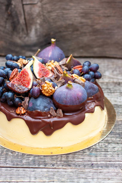 istock Delicious vanilla cheesecake poured with melted dark chocolate, figs, grape, pecan nuts on the top. Harvest autumn decoration 1794985657