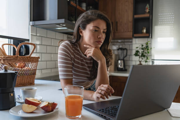 istock Young entrepreneur women working from home, looking at papers and using a notebook computer 1794986195