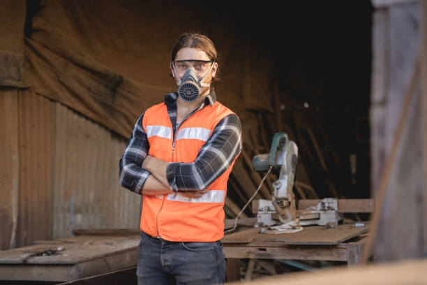 istock Young male carpenter working on design and cutting wood in the workshop, using a circular saw to cut a large board of wood on a wooden table in the workshop 1794995502