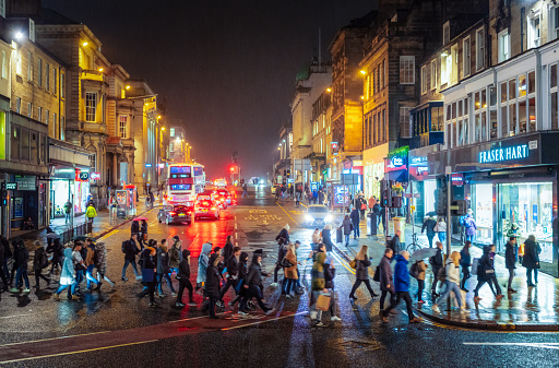 Edinburgh, Scotland - Pedestrians on Princes Street in central Edinburgh, crossing Hanover Street after dark during winter.