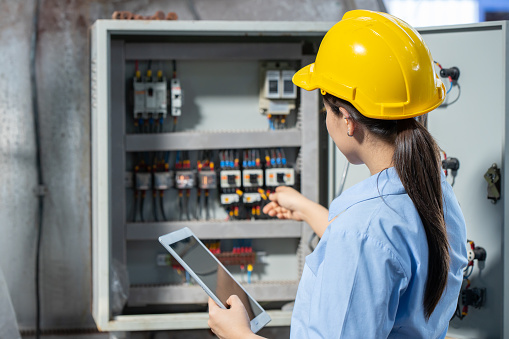 Electrician Engineer woman working check service maintenance electricity main circuit fuse and power system in industry factory