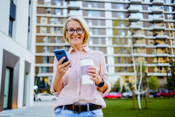 istock Mature woman using phone outdoors 1795004036