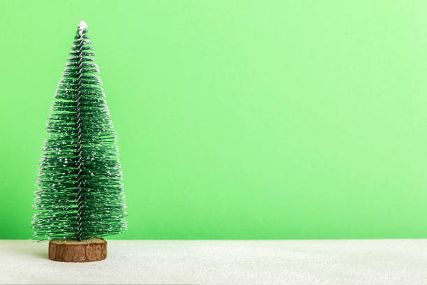 istock One small Christmas tree on colored background. new year decoration with copy space 1795005753