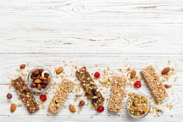 varias barras de granola sobre el fondo de la mesa. barras de granola de cereales. barritas de desayuno de superalimentos con avena, nueces y bayas, de cerca. concepto de superalimento - protein bar cereal oat cranberry fotografías e imágenes de stock