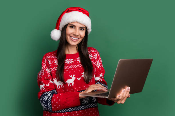 Photo of shiny positive lady santa helper dressed print xmas sweater texting twitter telegram facebook isolated green color background stock photo