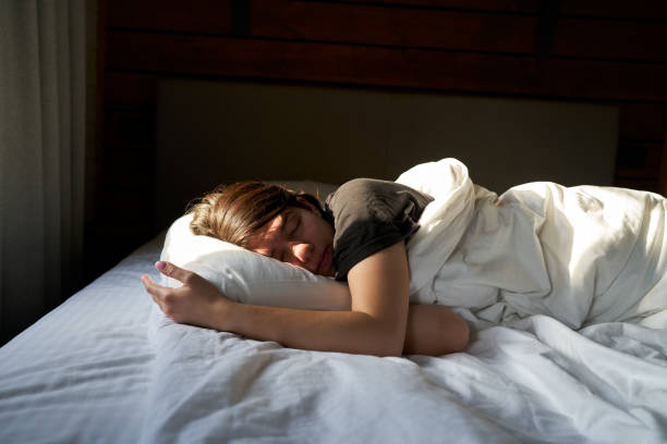istock Female is sleeping cozily on a bed at the bedroom. 1795009127