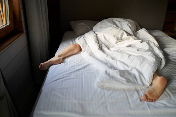 istock Female is sleeping cozily on a bed at the bedroom. 1795009688