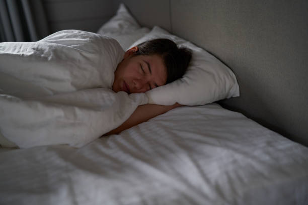 istock Female is sleeping cozily on a bed at the bedroom. 1795010210