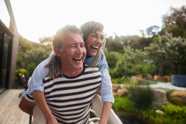 istock Mature man carrying his wife on his back while having fun in summer 1795012374