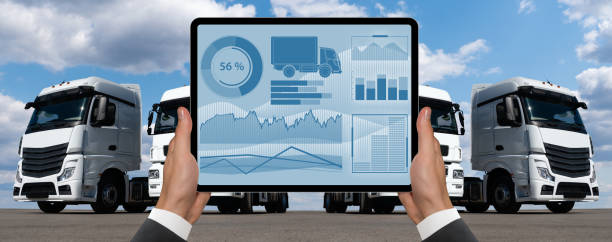 istock Manager with a digital tablet on the background of trucks 1795026428