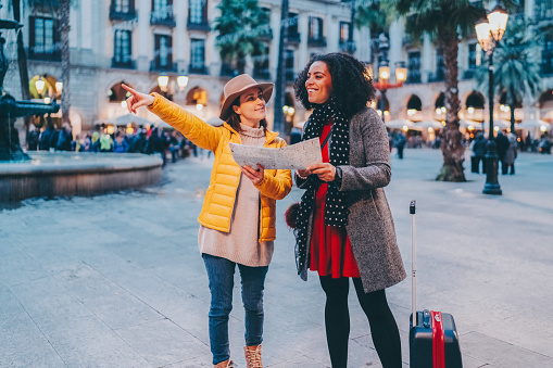 Woman just arriving in Barcelona asking local girl for help to find the hotel