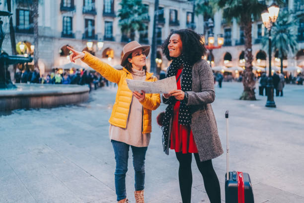 Woman just arriving in Barcelona asking local girl for help to find the hotel stock photo