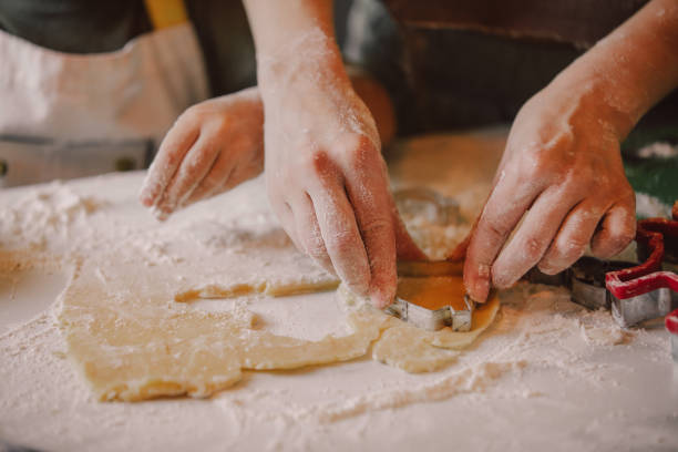 Closeup view on hands how mother with son preparing flour for cookies in the kitchen