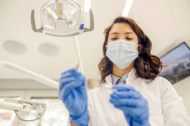 istock A dentist with mask is doing oral checkup at dentist office. 1795047102
