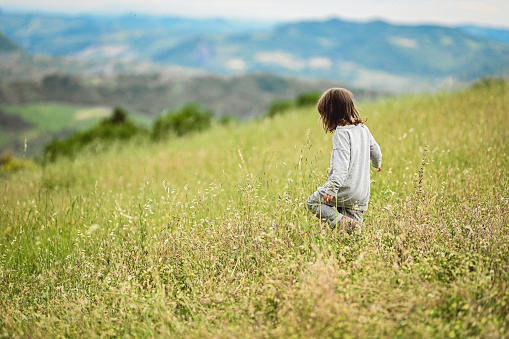 Little girl is relaxing on meadow.