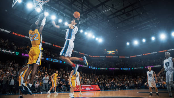 lo más destacado del campeonato de baloncesto en el canal de noticias de televisión en vivo: jugador del equipo blanco pasando el balón a través de la defensa. un jugador de baloncesto negro anota una volcada exitosa con una mano - basketball fotografías e imágenes de stock