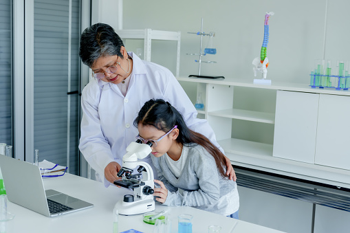 Teacher gives youngest female student in science class tutoring on weekends, get up, look through microscope look at substances being studied, tell story elders in class.