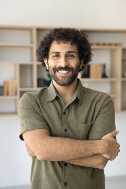 istock Cheerful handsome young Arab entrepreneur guy posing indoors 1795068462