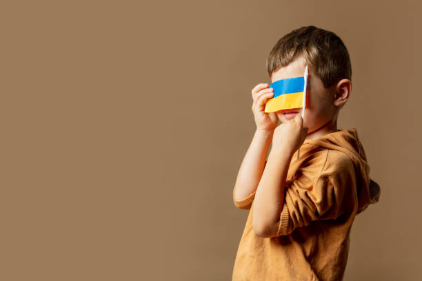 istock Little kid boy with Ukrainian flag on brown background 1795072957
