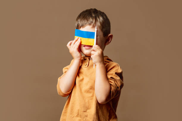 istock Little kid boy with Ukrainian flag on brown background 1795074587
