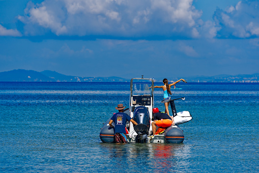 People loading motor boat with wing foil equipment at bay of Giens Peninsula on a sunny late spring day. Photo taken June 8th, 2023, Giens, France.