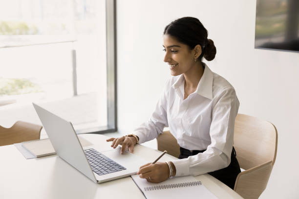 istock Happy Indian office employee girl using laptop for Internet communication 1795080165
