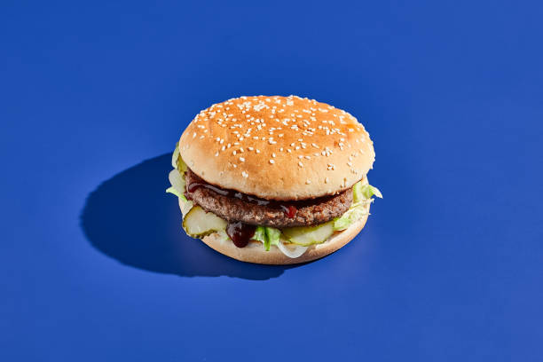istock Beef burger blue background with hard shadow. American junk food minimal style. Hamburger trendy style.  Simple burger colour background. 1795084432