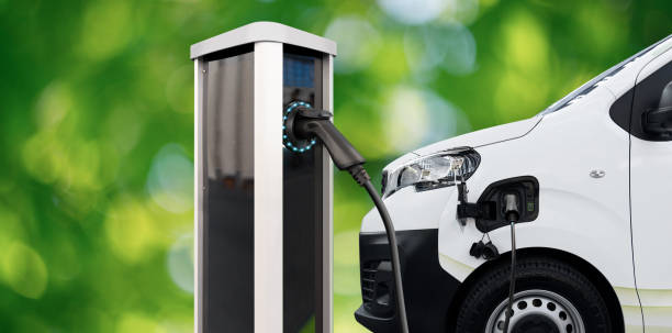 istock Electric delivery van with charging station on a green background 1795086103