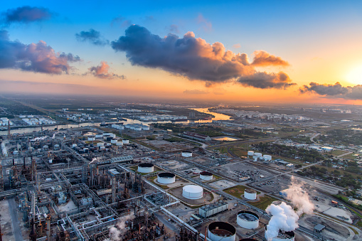 Wide angle aerial view of Texas refineries and other industry along the Buffalo Bayou dredged to form the Houston Ship Channel located about 4 miles east of downtown Houston, Texas shot aerially via helicopter from an altitude of about 500 feet at sunrise.