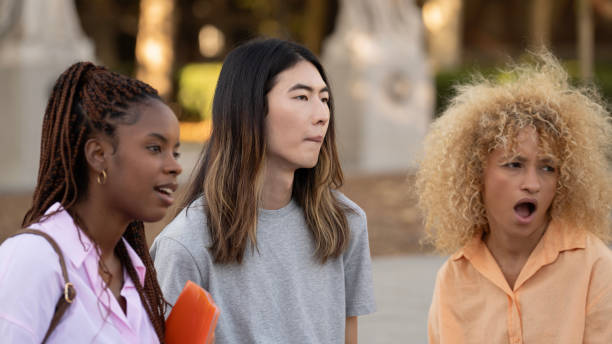 istock Multi ethnic Students looking away with expression of surprise in the face standing on a campus 1795132653