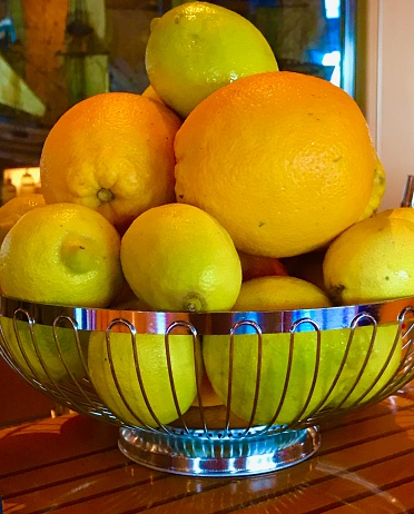 Oranges, lemons, and limes in a wire basket