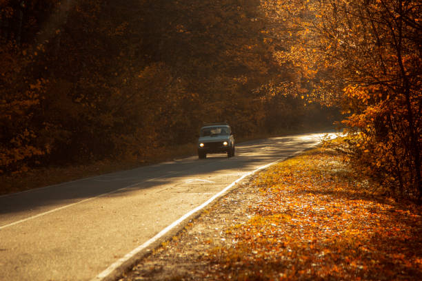 istock winding rual road with car inside colorful autumn forest 1795149428