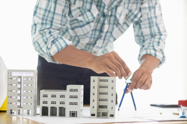istock Building models and blueprints are placed on work desks in the construction engineering team offices to plan construction to achieve their goals and to simulate building models for clients to see. 1795150467