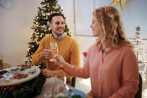 Young couple having celebratory toast during Christmas dinner