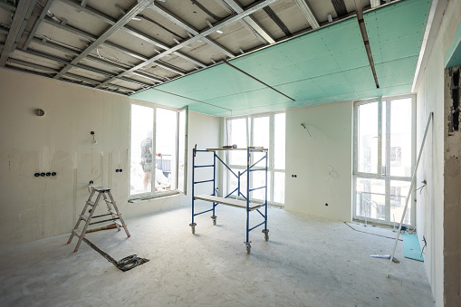 Drywall installation work in progress by construction workers at construction room. easiest and cheapest way to do partition for interior wall. New home for under construction. protection building . High quality photo