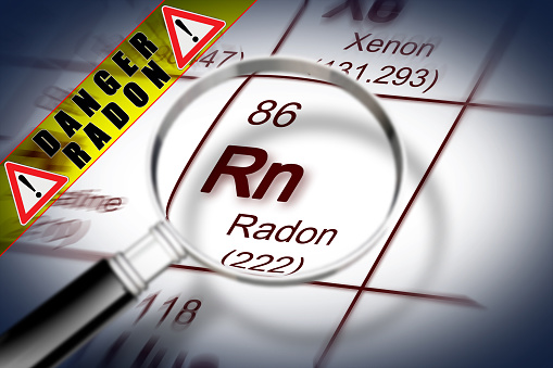 The danger of radon gas - concept image with periodic table of the elements and magnifying lens