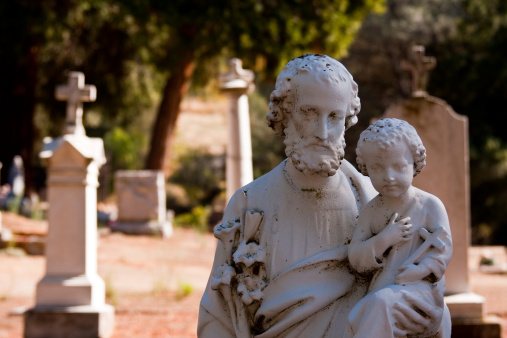 A statue with a child and a priest