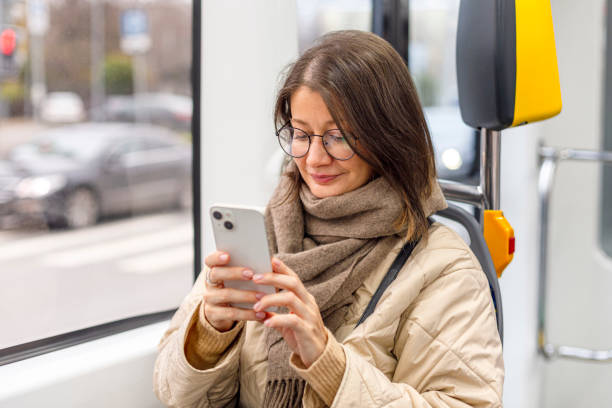 istock Happy woman commuting on a bus and checking her cell phone 1795191162