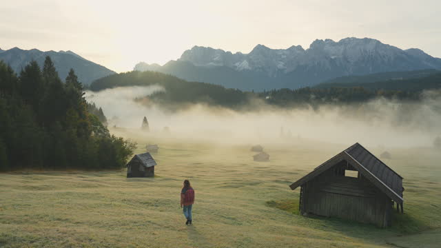 Woman walking through  the fog in Bavarian Alps