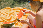 Stylish woman eats watermelon in outdoor in summer