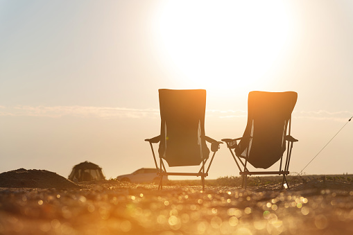 Two empty camping chairs on the ground. An ideal place to watch sunset or sunrise. Active relaxing lifestyle.