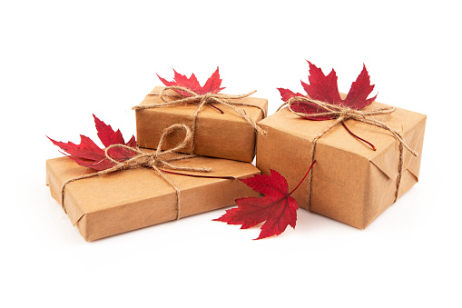 Gift box with maple leaves isolated on white background