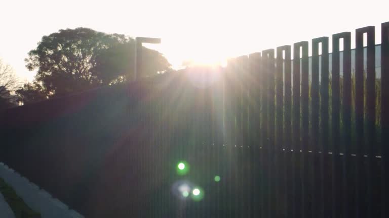 Sun rays, sunbeams from behind metal fence